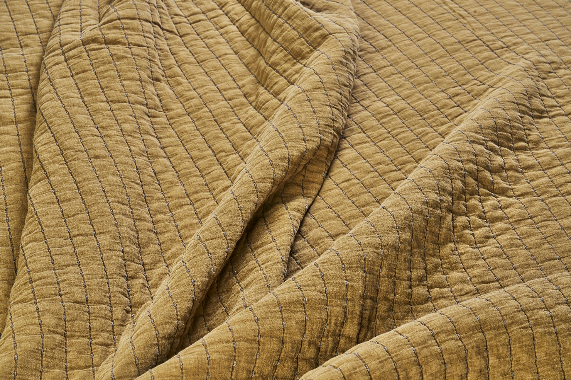 Quilted cotton bed cover in mustard gold and grey | Minerva Interiors
